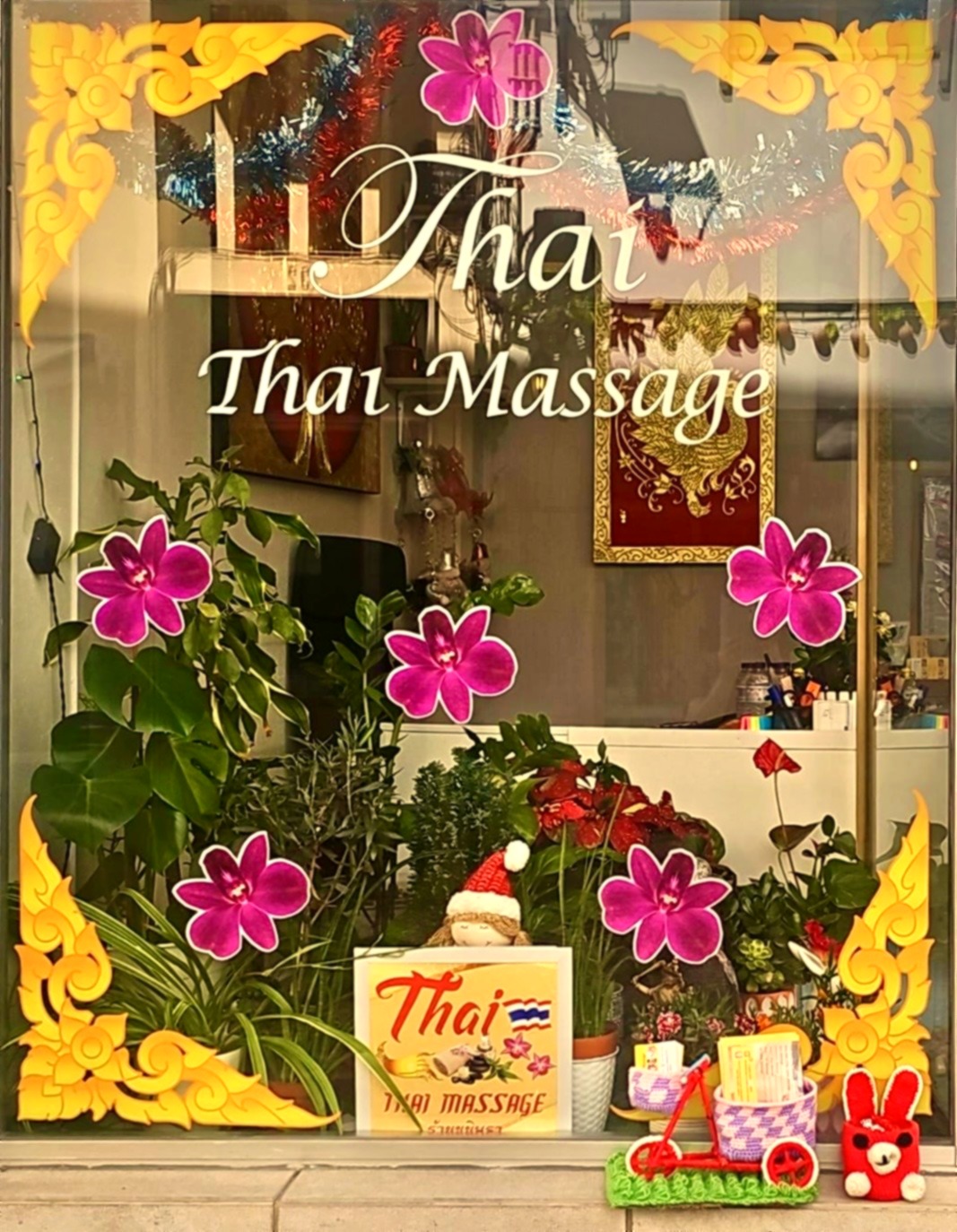 Thai Thai Massage shop window in Lagos with gold decorations, pink flowers and plants